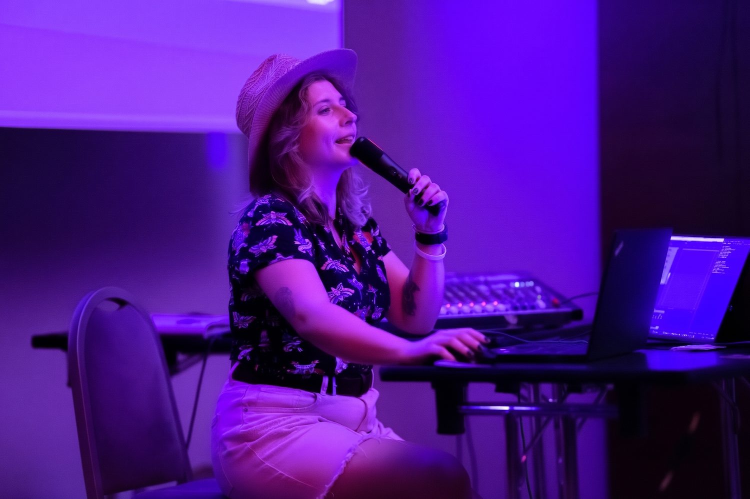 Dominika prowadzi quiz przy mikrofonie, laptopie i mikserze